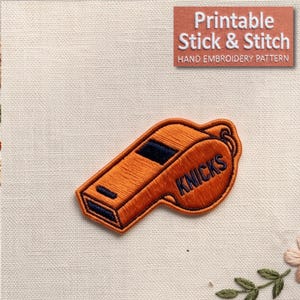 May include: An embroidered patch of an orange whistle with dark blue accents and the text KNICKS stitched in dark blue. The patch is displayed on a light-colored fabric background. A rectangular label in the top right corner reads Printable Stick & Stitch HAND EMBROIDERY PATTERN.