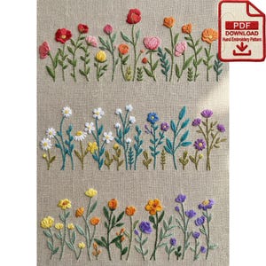 Op de afbeelding: Geborduurd bloemenontwerp op een beige stof. De borduursels bevatten rijen kleurrijke bloemen in rood, roze, geel, oranje, blauw en paars. Een PDF-downloadpictogram staat rechtsboven.
