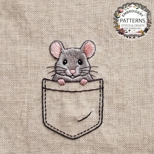 Puede incluir: Un diseño de bordado que muestra a un pequeño ratón gris con orejas y nariz rosadas asomándose por el bolsillo de una camisa. El ratón tiene ojos y bigotes negros, y el bolsillo está delineado con hilo negro sobre una tela beige texturizada.