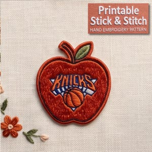 May include: An embroidered patch shaped like an apple in shades of orange and red with a green leaf. The center features the blue and white text "KNICKS" above an orange basketball graphic. A small orange flower is embroidered in the lower left corner.