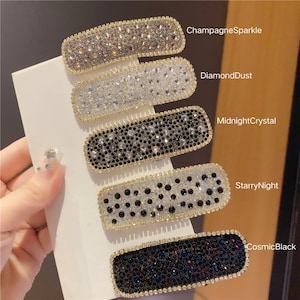 May include: Five rectangular hair clips with sparkling embellishments. The clips are labeled ChampagneSparkle, DiamondDust, MidnightCrystal, StarryNight, and CosmicBlack. Each clip has a gold-colored border.