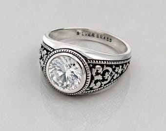 Anello solitario da uomo in stile vintage, con zircone bianco rotondo e fascia in ottone argentato con lavorazione a filigrana.