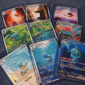 Könnte beinhalten: Eine Sammlung von Pokémon-Sammelkarten, darunter Charizard, Blastoise und Venusaur, in Schutzhüllen. Die Karten zeigen farbenfrohe Illustrationen und Spielinformationen.