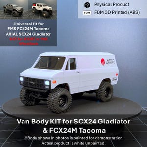 May include: A white FDM 3D printed van body kit for SCX24 Gladiator and FCX24M Tacoma RC vehicles. The model features a black grille with GMC lettering, large off-road tyres, and a red circular logo with the text MODS RACING on the side panel.
