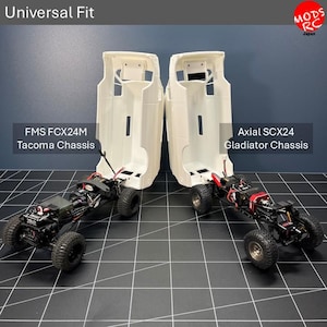 May include: Two white remote-controlled truck bodies positioned over chassis, labelled Universal Fit, FMS FCX24M Tacoma Chassis, and Axial SCX24 Gladiator Chassis. The bodies are hollow shells with black wheels and mechanical components visible below.