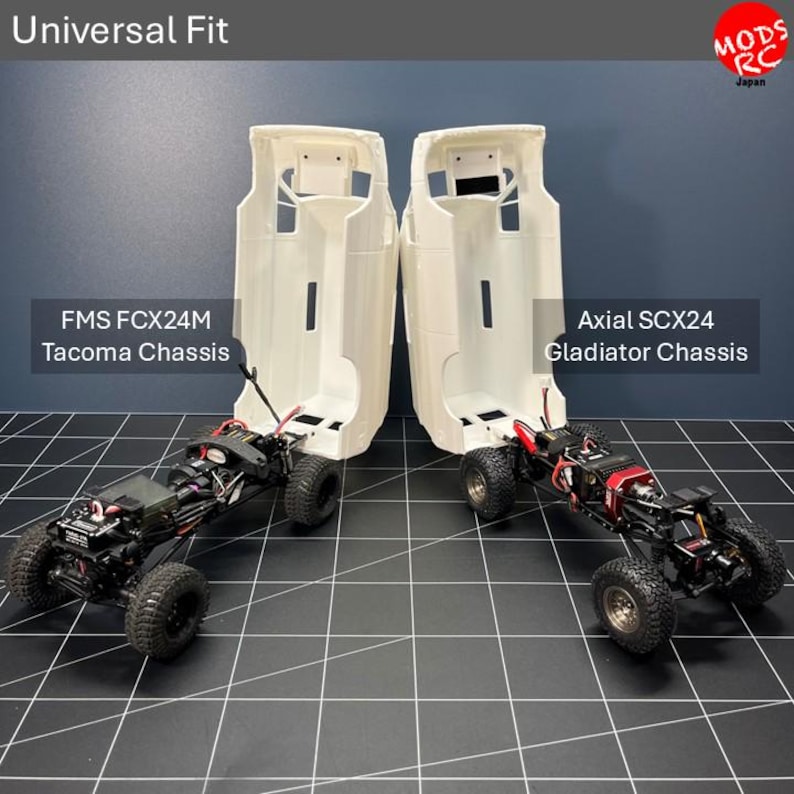 May include: Two white remote-controlled truck bodies positioned over chassis, labelled Universal Fit, FMS FCX24M Tacoma Chassis, and Axial SCX24 Gladiator Chassis. The bodies are hollow shells with black wheels and mechanical components visible below.