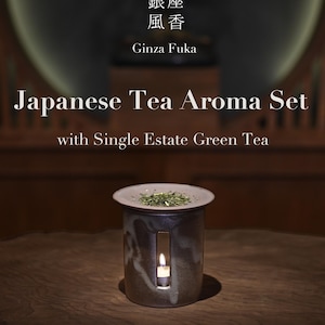 May include: A Japanese tea aroma set with single estate green tea. The ceramic aroma diffuser is cylindrical with a small rectangular opening and a lid. The text on the image reads "Ginza Fuka" and "Japanese Tea Aroma Set".