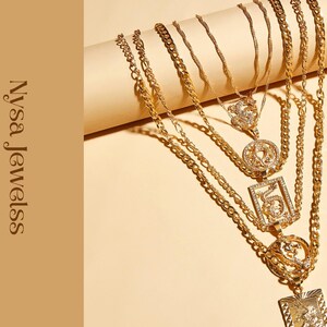 Puede incluir: Collares dorados con diferentes estilos de cadena y diseños de colgantes, incluyendo un colgante rectangular, uno circular y uno cuadrado. La imagen muestra el texto "Nysa Jewelss" sobre un fondo beige.