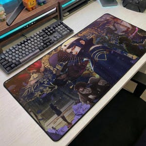 May include: A rectangular mouse mat with a detailed illustration of a character in a dark blue outfit with gold accents. The artwork has a fantasy theme with purple flowers and other figures. A black keyboard is visible to the left.