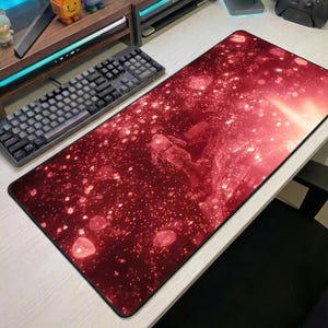 May include: A large rectangular mouse pad with a red and black space-themed design. The image features an astronaut floating in a starry galaxy. The mouse pad is designed to fit a keyboard and mouse.