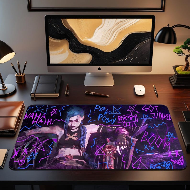 May include: A rectangular desk mat featuring a character illustration with blue hair and a dark outfit. The design includes neon blue and purple graffiti-style text and star shapes on a black background. The text includes "HAHA", "POW", and "BOOM".