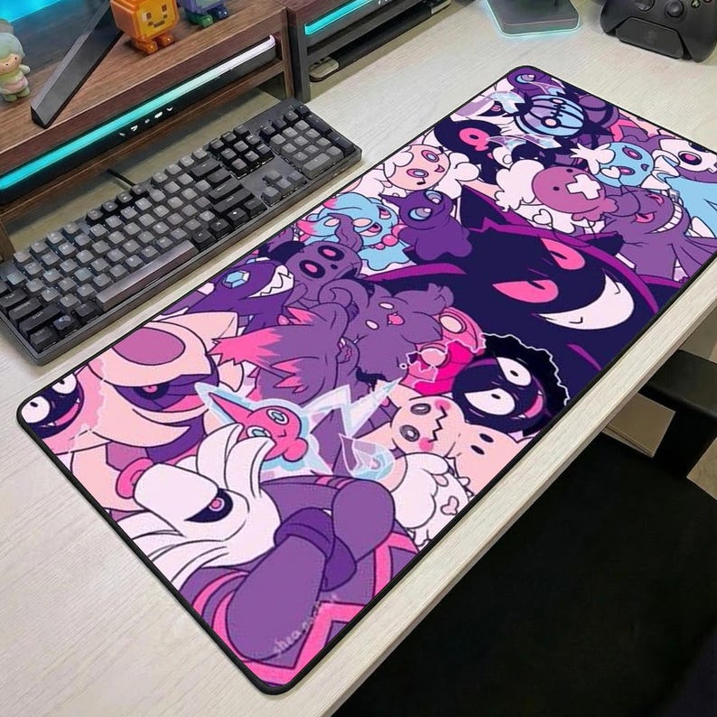 May include: A rectangular mouse mat with a vibrant design of cartoon characters in purple, pink, and blue hues. The artwork showcases various creatures with distinct features, set against a black border, suitable for a desk.