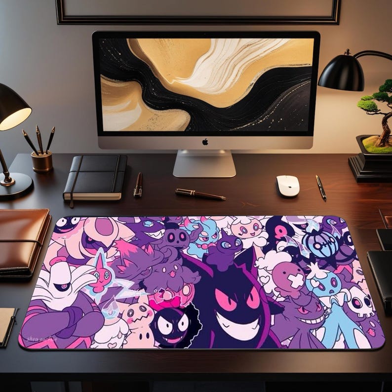 May include: A rectangular mouse mat with a vibrant design of cartoon characters in purple, pink, and blue. The mat is on a dark wooden desk, with a computer monitor and other office supplies in the background. The design is eye-catching.