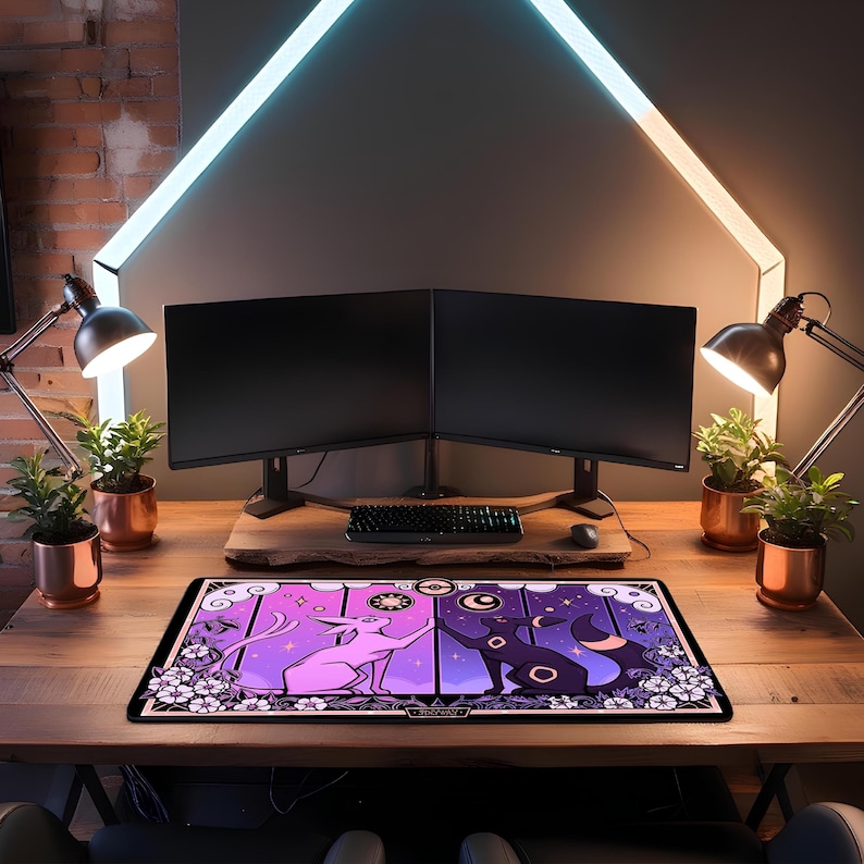May include: A rectangular desk mat featuring a purple and black cartoon cat design. The mat is placed on a wooden desk with two computer monitors, a keyboard, and a mouse. The background includes plants, lamps, and a decorative light.