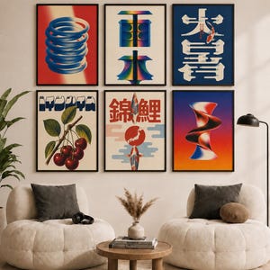 May include: A gallery wall featuring six framed art prints. The top row displays a blue coil on red, a blue and green geometric shape, and a blue poster with a koi fish. The bottom row shows cherries, a koi fish with Japanese text, and a red-to-blue gradient abstract form.