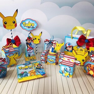 Może przedstawiać: Kolekcja dekoracji na przyjęcie z motywem Pikachu. Zawiera pudełka, torby na prezenty i wycinanki postaci. Dekoracje przedstawiają Pikachu, Asha i inne postacie z Pokémonów. Schemat kolorów to głównie żółty, czerwony, niebieski i biały.