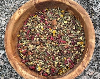 May include: A wooden bowl filled with a blend of dried herbs, spices, and fruit pieces. The mixture includes red berries, cinnamon sticks, and dried flowers.