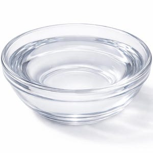 May include: A clear glass bowl containing a transparent liquid, possibly water. The bowl has a simple, rounded design with a slightly flared rim. The image is well-lit, highlighting the clarity of the glass and the liquid within.