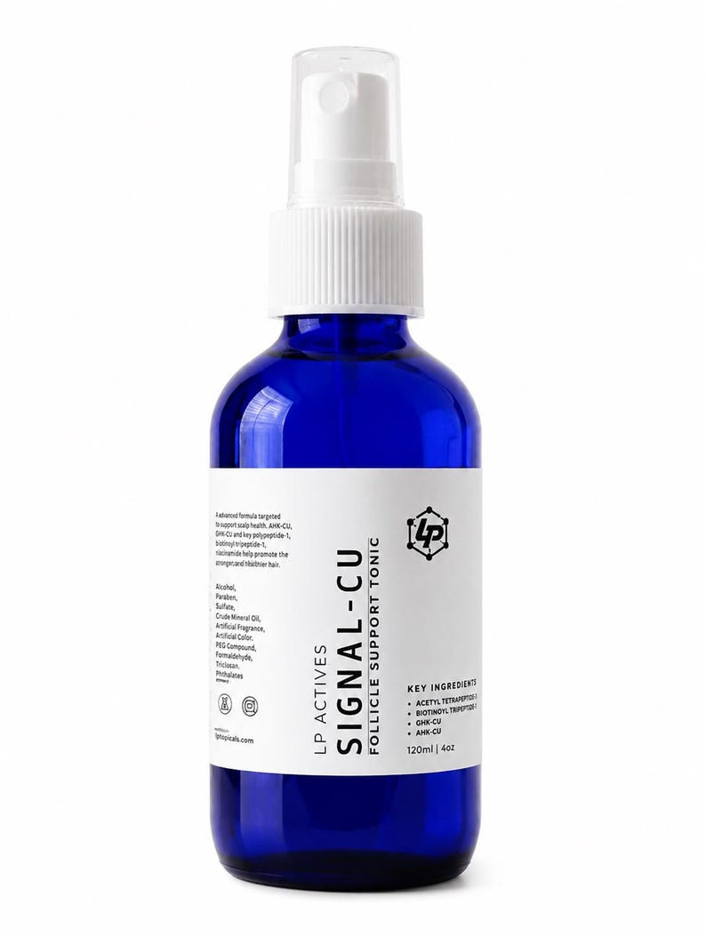 May include: A cobalt blue glass spray bottle with a white pump top and a white label. The label reads LP ACTIVES SIGNAL-CU FOLLICLE SUPPORT TONIC, lists key ingredients like GHK-CU and AHK-CU, and states a volume of 120ml | 4oz.