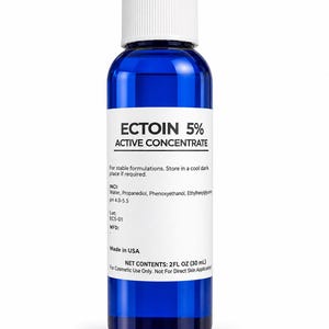 May include: A blue glass bottle with a white screw cap containing Ectoin 5% Active Concentrate. The white label displays the product name, ingredients, pH 4.0-5.5, lot number EC5-01, and net contents of 2 fl oz (30 ml) for cosmetic use only.