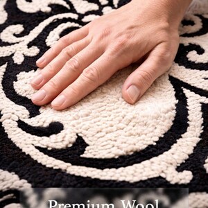 May include: A black and cream rug featuring a high-pile, tufted damask pattern. The surface has a textured, looped construction with a soft appearance. The text "Premium Wool" is overlaid at the bottom of the image in a clear, white font.