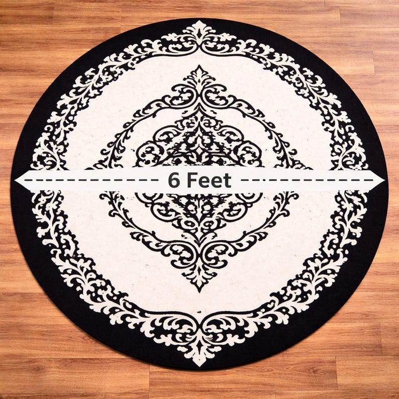 May include: A circular rug featuring a black and white damask pattern with a central ornate motif and a wide decorative border. A horizontal graphic overlay across the center indicates a diameter measurement of 6 Feet.