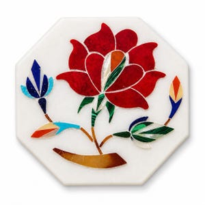 Op de afbeelding: Een achthoekige witte marmeren onderzetter met een bloemeninlegontwerp. De bloem heeft rode bloemblaadjes, groene bladeren en een veelkleurig centrum. Twee knoppen en stelen met kleurrijke accenten maken het ontwerp compleet.