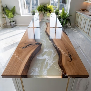 Könnte beinhalten: Ein maßgefertigter Kücheninsel aus Holz mit einem Fluss aus weißem Epoxidharz. Die Insel hat eine natürliche Holzmaserung mit glänzendem Finish. Das Epoxidharz fließt durch die Mitte und schafft ein einzigartiges Design. Ca. 240 cm lang.