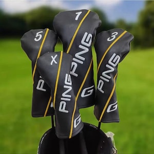 Puede incluir: Un juego de fundas para palos de golf negras con texto "PING" en blanco y rayas amarillas. Cada funda está etiquetada con un número o letra blanca: 1, 3, 5 y X. Las fundas están en una bolsa de golf.