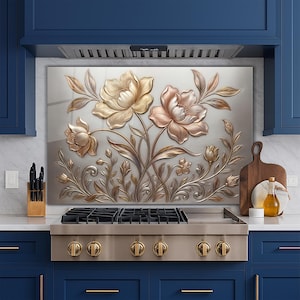 May include: A decorative kitchen backsplash featuring a floral design with embossed flowers in gold and rose gold tones. The flowers and leaves are set against a light gray background, creating a 3D effect. The backsplash is installed above a stainless steel gas range.