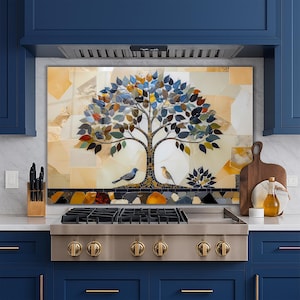 May include: A mosaic backsplash featuring a tree with colorful leaves and two birds. The mosaic is set against a backdrop of beige and gold tiles. The kitchen features a stainless steel stove and navy blue cabinets.