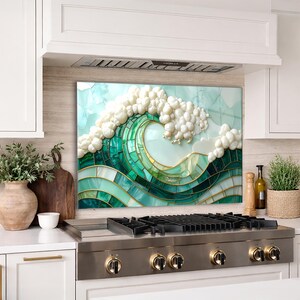 May include: A mosaic art piece depicting a breaking ocean wave. The wave is rendered in shades of green and teal, with white foam and gold accents. The artwork is displayed above a stainless steel stove.