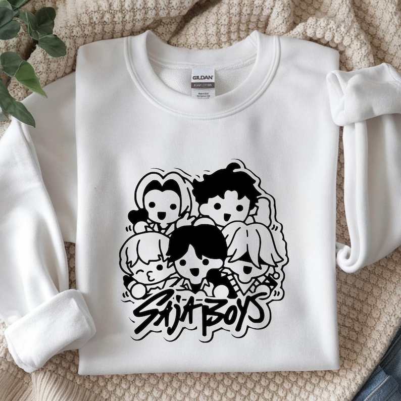 May include: White crewneck sweatshirt featuring a black and white graphic of five cartoon figures. The text "Skit Boys" is below the figures in a stylized font. The sweatshirt is made of a soft material.