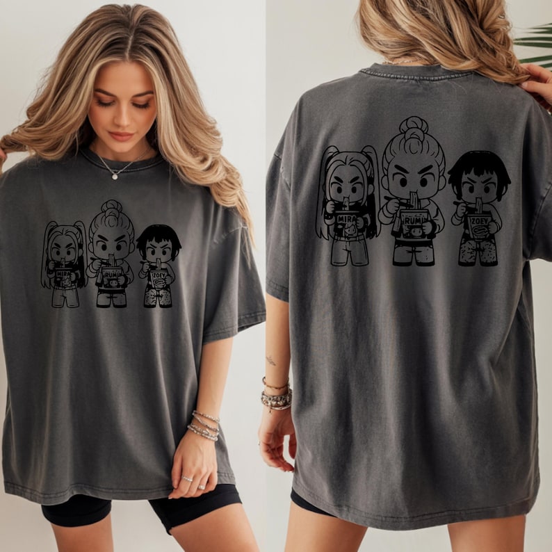 May include: Dark gray t-shirt featuring a black graphic of three cartoon figures holding drinks. The figures are on the front and back of the shirt. The shirt is a comfortable, oversized fit.