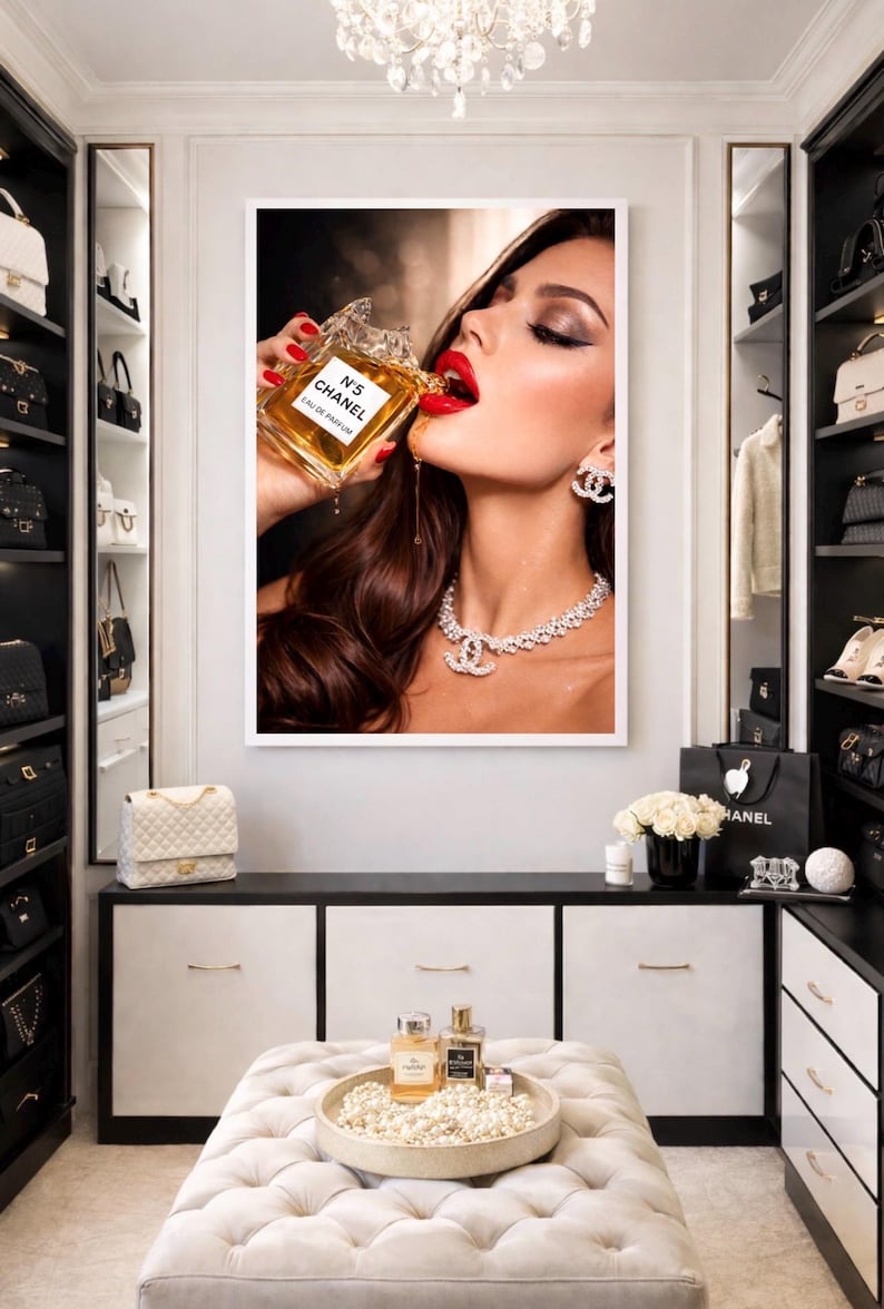 Puede incluir: Una impresi&oacute;n enmarcada que presenta a una mujer con l&aacute;piz labial rojo, que lleva un collar y aretes de diamantes, bebiendo de un frasco de perfume Chanel N&deg;5. La imagen est&aacute; ambientada en un lujoso armario con decoraci&oacute;n en blanco y negro.