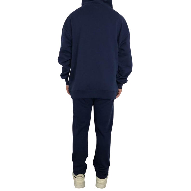 May include: Navy blue hoodie and matching sweatpants set. The hoodie has a drawstring hood and long sleeves. The sweatpants have a straight leg design. The person is wearing white sneakers. The set is made of a soft, comfortable material.