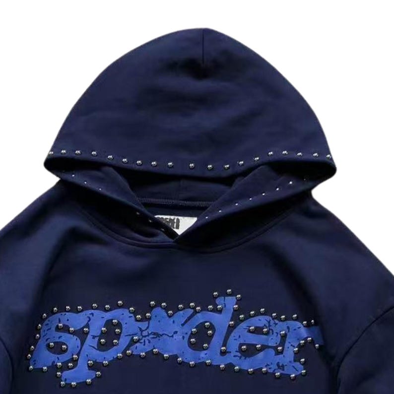 May include: Navy blue hoodie with the word "Spyder" in blue, studded with silver rivets. The hood is also studded with silver rivets. The hoodie is made of a soft material.