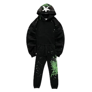"Black hoodie and jogger set featuring neon green spiderweb graphics and small star accents. The hood has a black-and-white camo design with a white star. Casual loungewear with elastic cuffs and drawstring waist, perfect for streetwear or cozy outfits."
