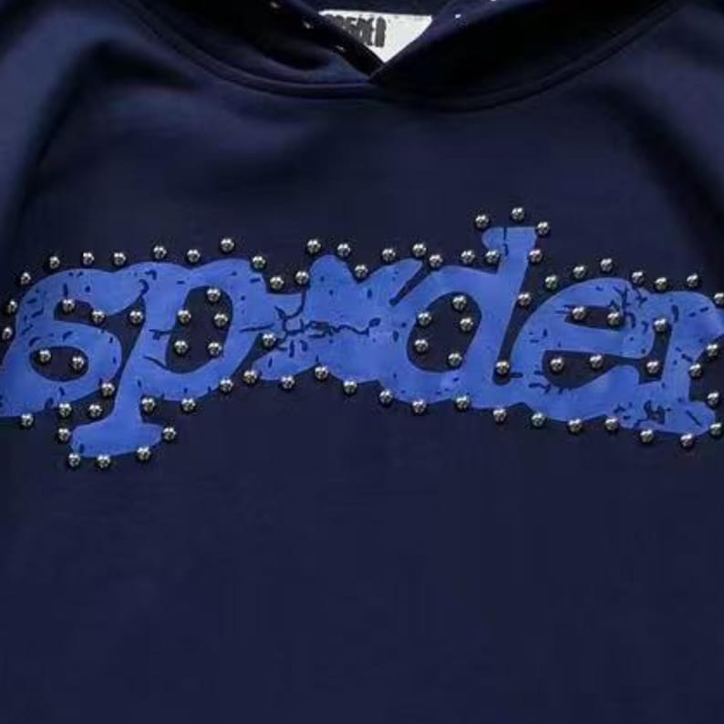 May include: Navy blue hoodie with the word "Spyder" in a distressed blue font, studded with silver-colored embellishments. The hoodie has a drawstring hood and is made of a soft material.