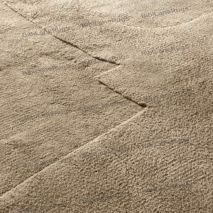 May include: Close-up of a beige rug with a textured surface. The rug has a geometric design with straight lines and angles. The rug is made of a soft, plush material, and the color is a neutral beige.