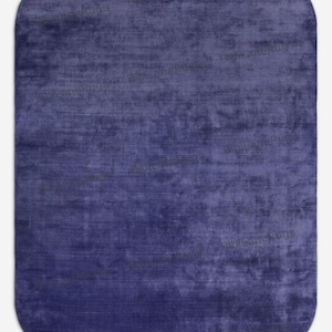 May include: An indigo-coloured rug with rounded corners. The rug has a textured appearance, with subtle variations in the blue hue, creating a soft, inviting look. Suitable for living rooms and bedrooms. The rug's dimensions are in centimetres.