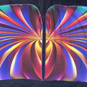 May include: Two rectangular fabric panels with a vibrant, abstract design. The pattern features radiating lines in shades of blue, purple, orange, yellow, and red, creating a dynamic, colorful visual effect. The edges are finished with a purple trim.
