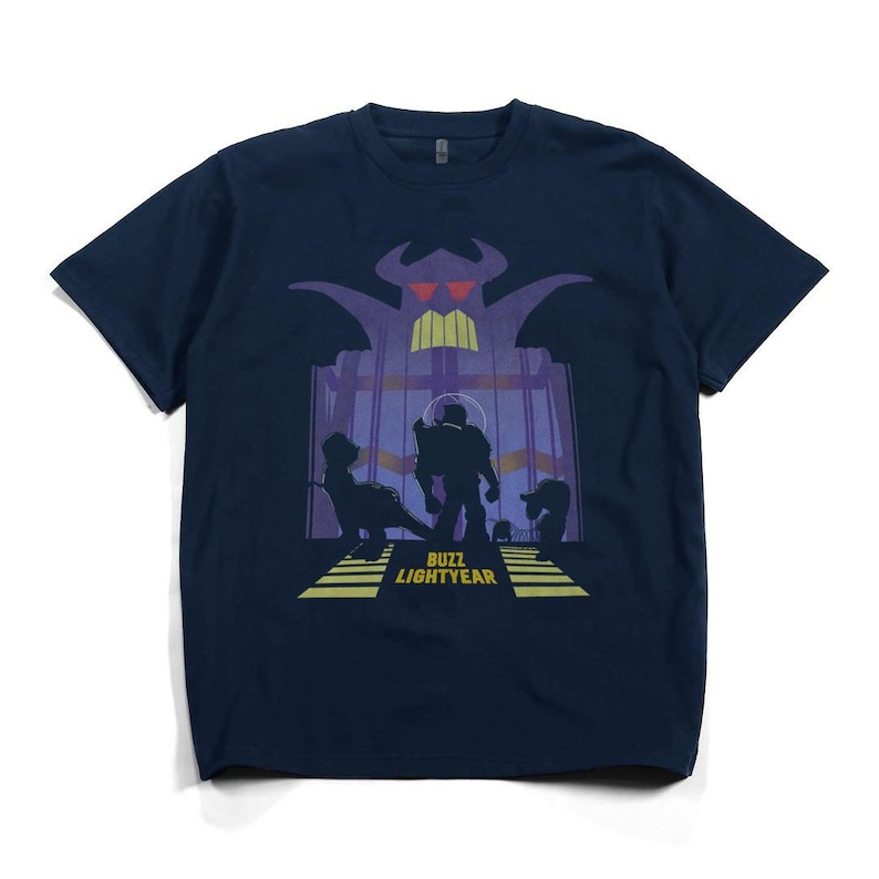 K&ouml;nnte beinhalten: Marineblaues T-Shirt mit einer Grafik aus dem Film Toy Story. Das Design zeigt Silhouetten von Charakteren und den Text "BUZZ LIGHTYEAR" in Gelb. Die Grafik ist vor einem lila und gelben Hintergrund platziert.