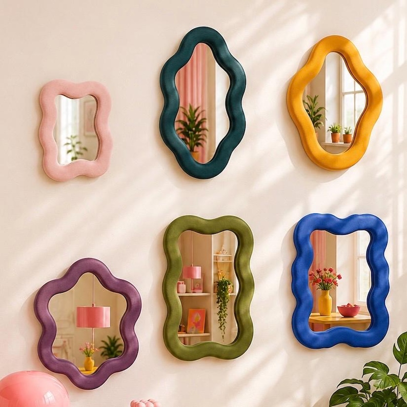 May include: A collection of six wall mirrors with wavy, irregular frames in various colors including pink, dark teal, yellow, purple, olive green, and blue. Each mirror features a reflective glass center surrounded by a thick, smooth, curved border.