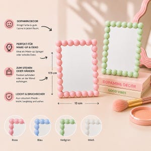 Può includere: Due specchi rettangolari con cornici composte da piccole sfere uniformi. Uno specchio è rosa chiaro e l'altro verde chiaro. Un diagramma indica le dimensioni di 13 cm per 17,5 cm. Gli specchi sono in plastica e possono essere appoggiati o appesi.