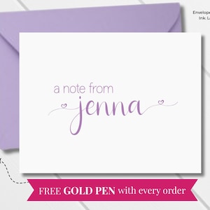 Puede incluir: Una tarjeta plegada con un sobre lavanda. La tarjeta presenta el texto "a note from jenna" en una escritura delicada, con pequeños acentos de corazón. Se incluye un bolígrafo dorado con cada pedido.