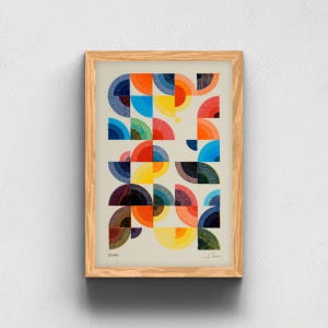 Peut inclure: Une impression d'art encadrée présentant une grille de demi-cercles colorés dans des tons de bleu, orange, rouge et jaune sur un fond crème clair. L'œuvre inclut des textures de lignes fines dans chaque forme, avec le texte 2026 et une signature.