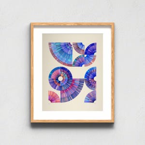 May include: A framed art print featuring a series of geometric, fan-shaped segments arranged in a circular and semi-circular pattern. The design uses a vibrant color palette of blue, purple, and pink, with fine radial lines creating a textured effect.