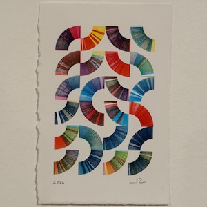 May include: Abstract art print featuring a repeating pattern of colorful, semi-circular shapes. The artwork uses a variety of colors, including red, blue, yellow, and green, arranged in a grid-like composition. The paper has a rough, torn edge.