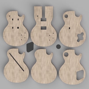 May include: Six flat, light-colored wooden guitar body cutouts arranged in two rows of three. Each piece features distinct laser-cut shapes, including circular holes, rectangular slots, and angled lines, representing various electric guitar designs.